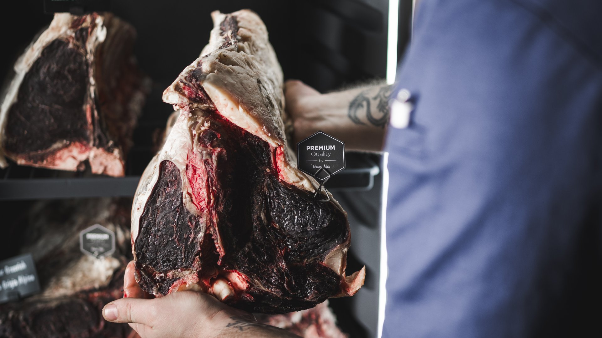 Mann inspiziert gereiftes Fleisch in einem Kühlschrank