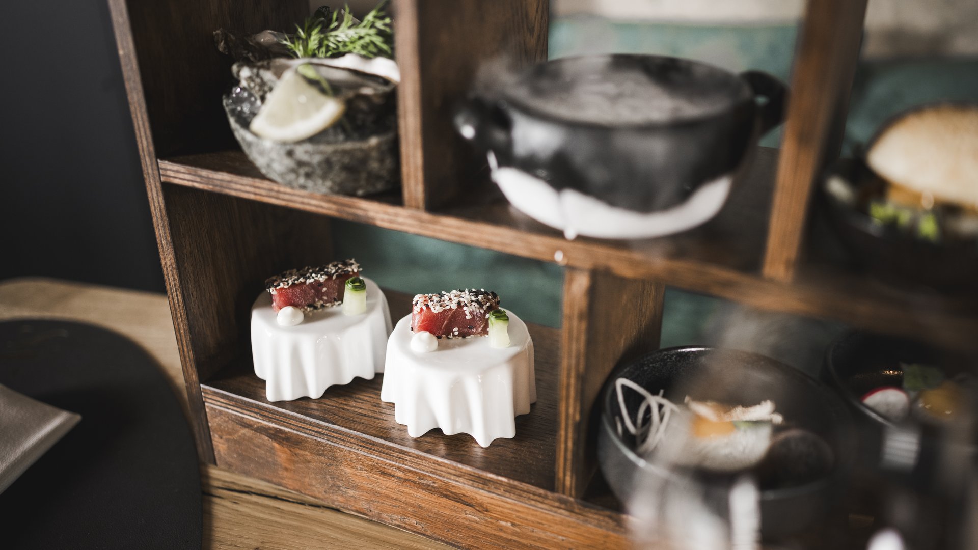 Verschiedene Gourmet-Häppchen auf Holzregal in moderner Präsentation