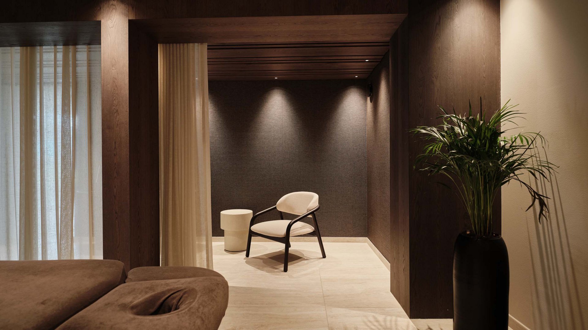 Moderner Entspannungsraum mit Sessel, Beistelltisch und großem Pflanzenvasen