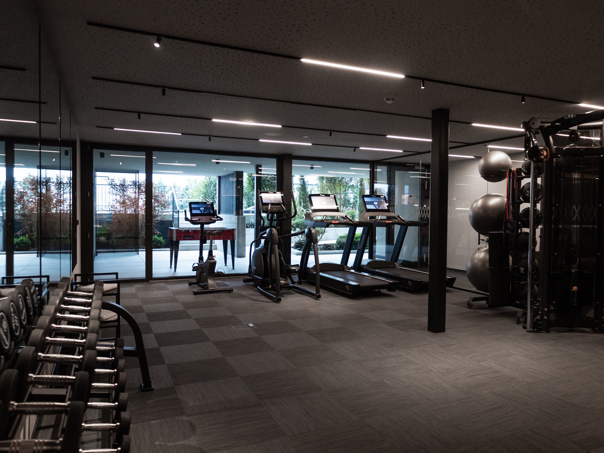 Moderne Fitnessstudio mit Hanteln, Laufbändern und Fitnessgeräten